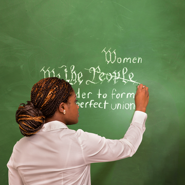 a person writing on a chalkboard