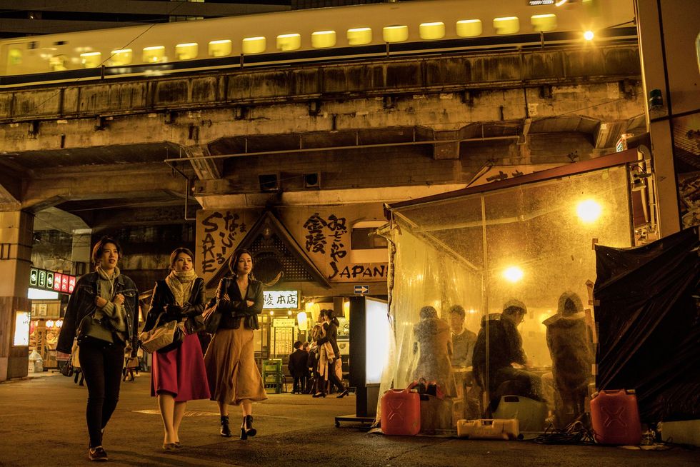 Yakitorirestaurants en izakayacafs liggen ingeklemd onder een spoorlijn in de bruisende wijk Yurakucho Veel van Tokios uitgaansbuurten moeten het hebben van de Japanse kantoorcultuur met zijn nomikai drinkfeestjes na het werk
