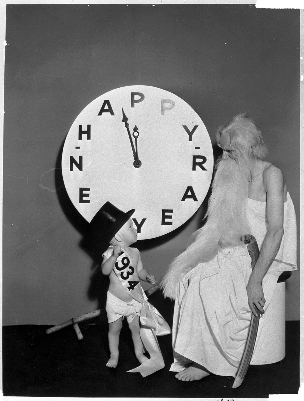 baby new year with father time by clock