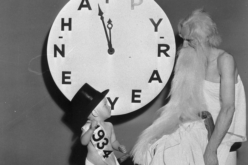 baby new year with father time by clock