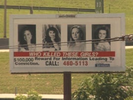 billboard seeking information about a crime involving missing girls includes four headshots and text