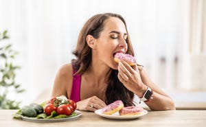 the young woman couldn't resist the sweet temptation, she excitedly bit into a sweet donut and gave preference to healthy vegetables