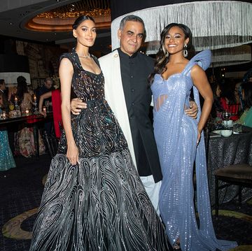 a person and two women in formal wear at a party