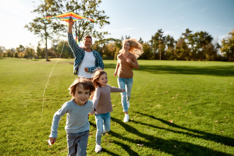 summer activities with a young family flying kites in the park