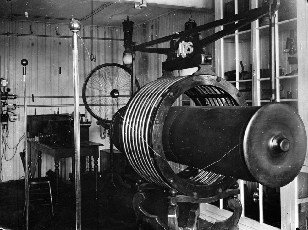 a large piece of machine with rings around a long tube sits in a room
