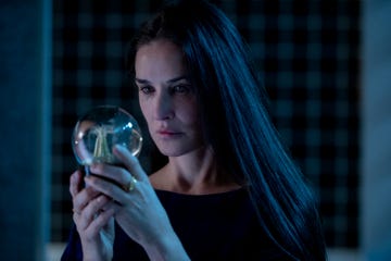 Person holding a glass orb in a dimly lit setting