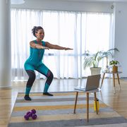 woman in blue workout clothes doing a squat workout at home