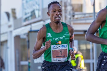 Runner competing in a 10K race wearing a green athletic shirt and bib number