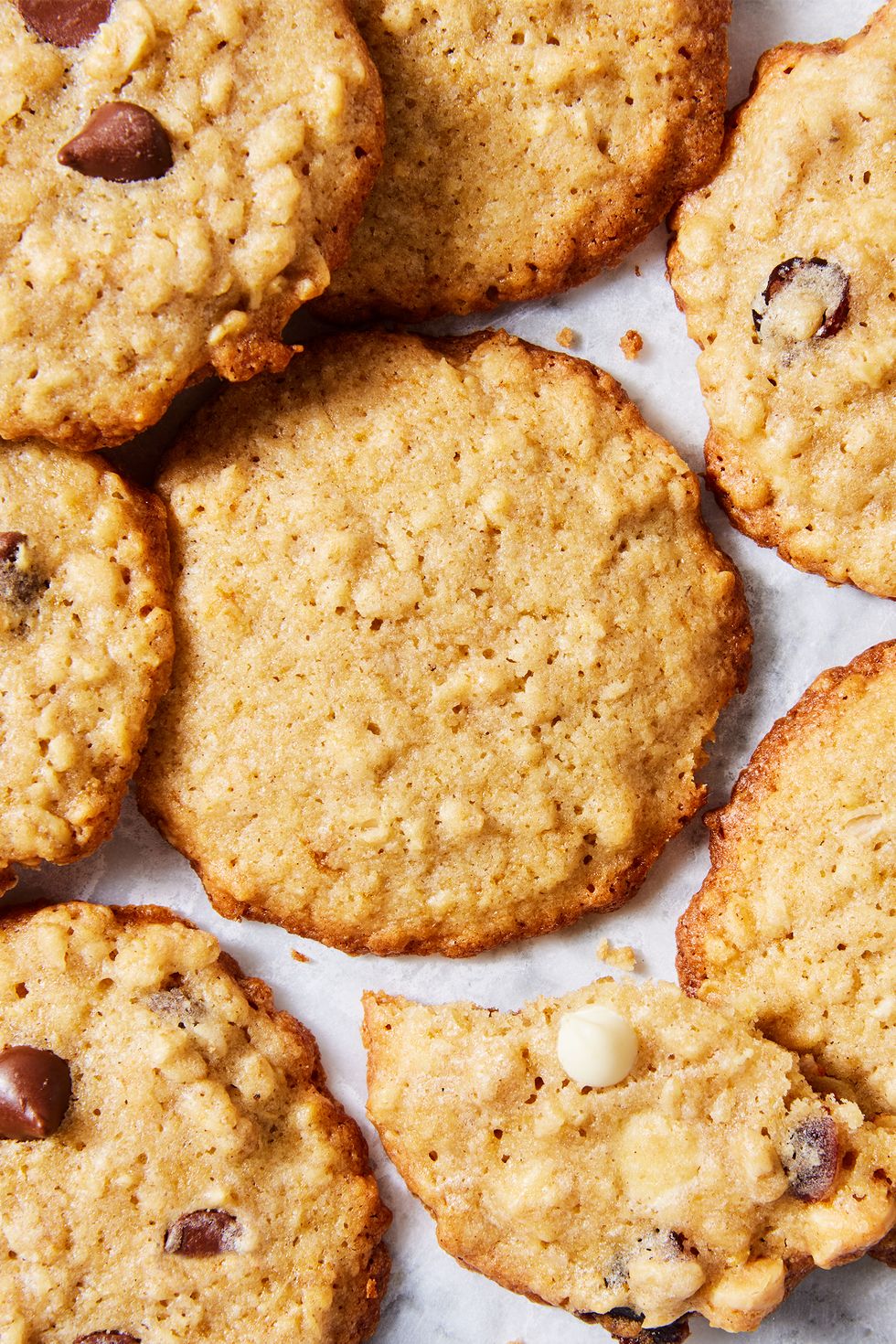 thin and crispy oatmeal cookies with chocolate chips, raisins, and white chocolate chips