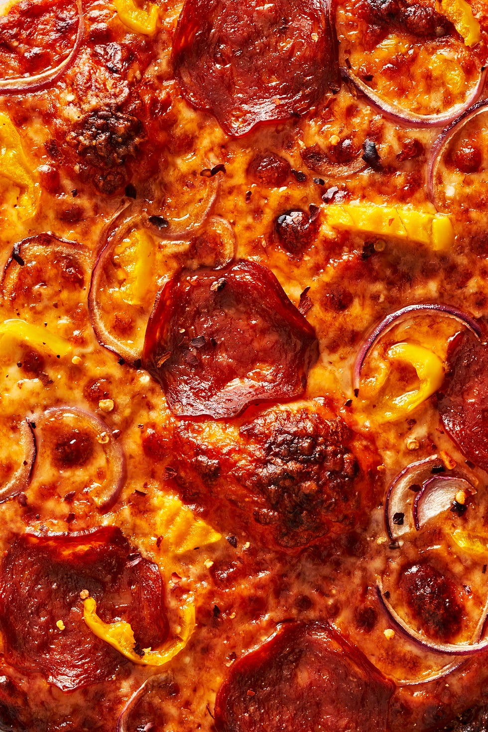 thin crust pizza with pepperoni, onions and banana peppers