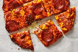 thin crust pizza with pepperoni, onions and banana peppers