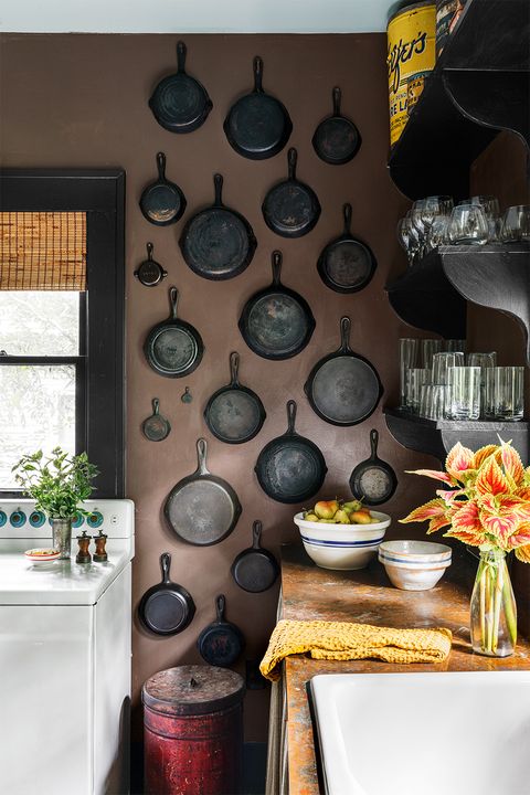 kitchen wall covered in old cast iron skillets