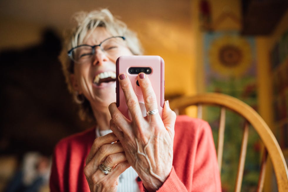 woman sitting in chair and holding phone and laughing, giving up not catching up with loved ones for lent