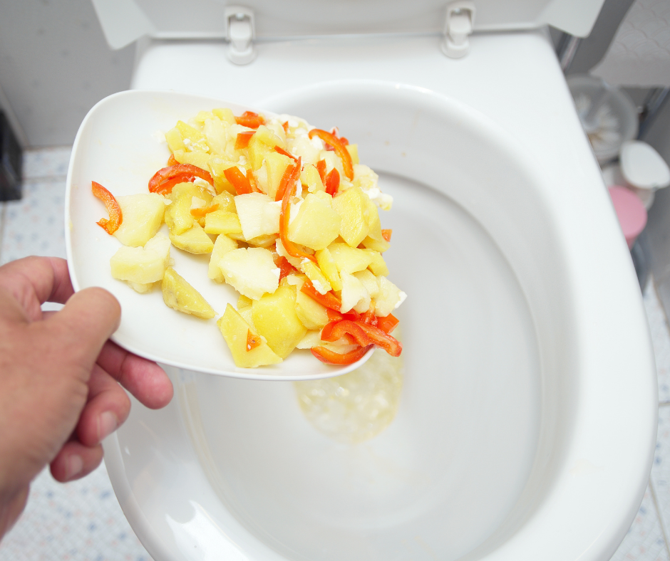 discarded food waste being thrown into a toilet bowl