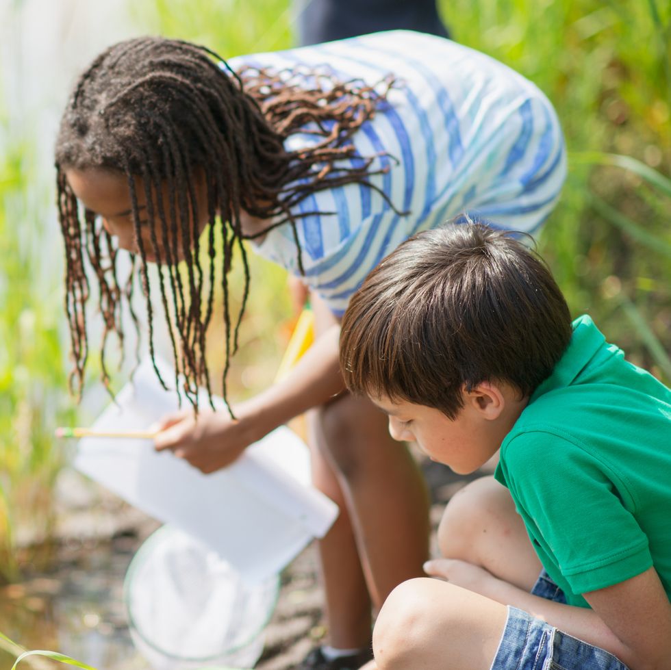 two children near a creek doing a science experiment