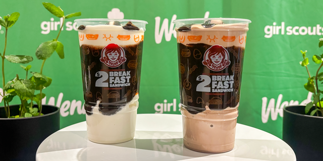 two beverage cups on display with branding placed on a white table