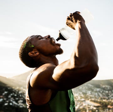 thirsty african american athlete drinking water with wide open m