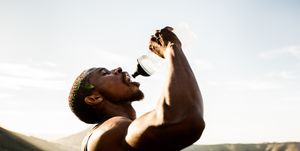 thirsty african american athlete drinking water with wide open m