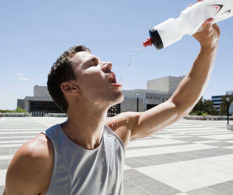 Thirsty runner drinking from water bottle