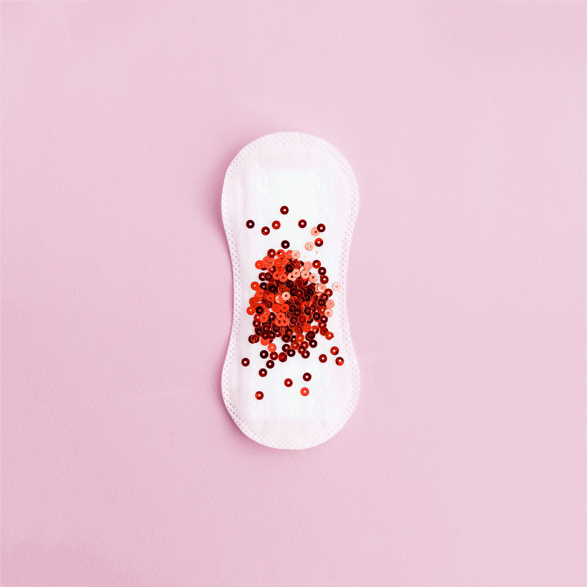 menstrual pad with red glitter on pastel background