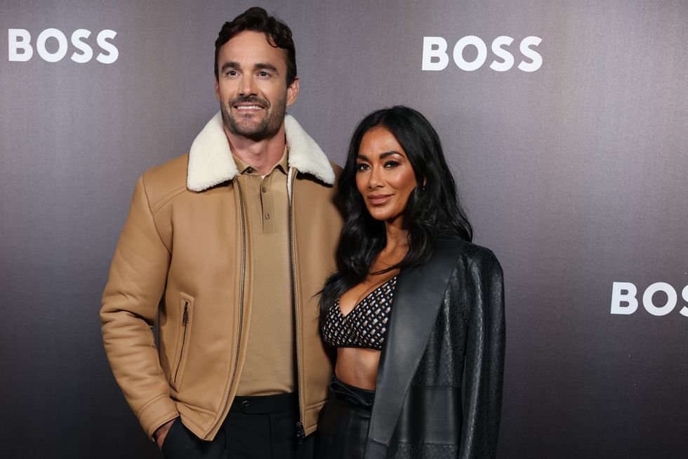 thom evans and nicole scherzinger smiling and posing for cameras at milan fashion week in september 2022