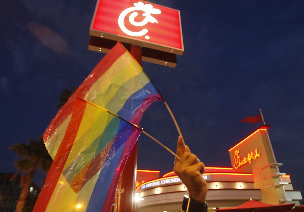 Thomas Guastavino, of the Cuddles gay men's choir, holds up gay pride flags while joining a group o