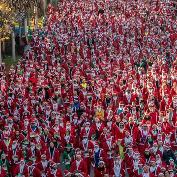 thousands of people dressed as santa claus running during