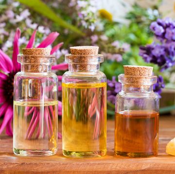 Three bottles of essential oil with frankincense, lavender, echinacea, chamomile and other herbs