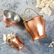set of 3 copper miniatures on concrete background with white flowers