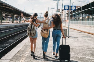 three friends enjoying a trip together rear view