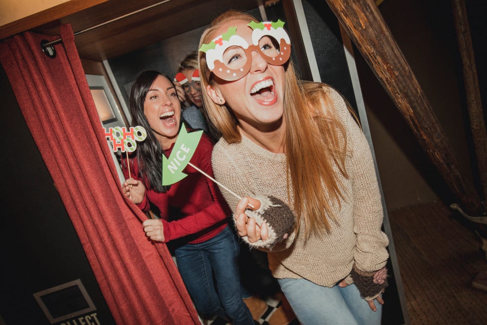three friends having fun in a photo booth