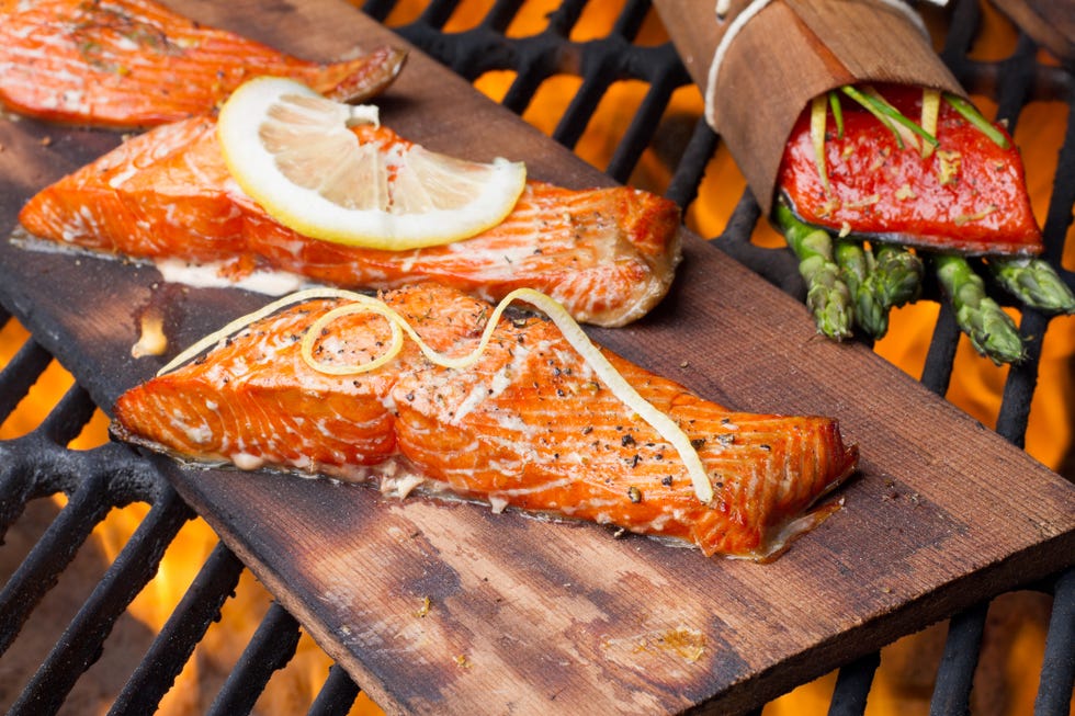 three grilled salmon fillets on cedar wood board