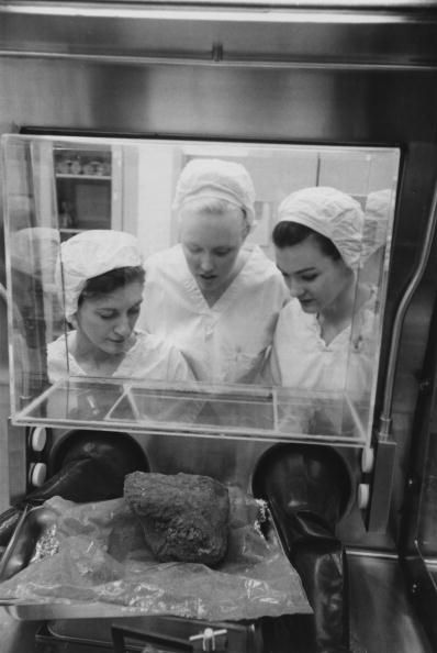 three lab technicians at the lyndon b johnson space center in houston texas examine a lump of rock brought back from the fra mauro area of the moon by the apollo 14 mission