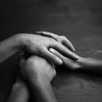 three people holding hands in black and white