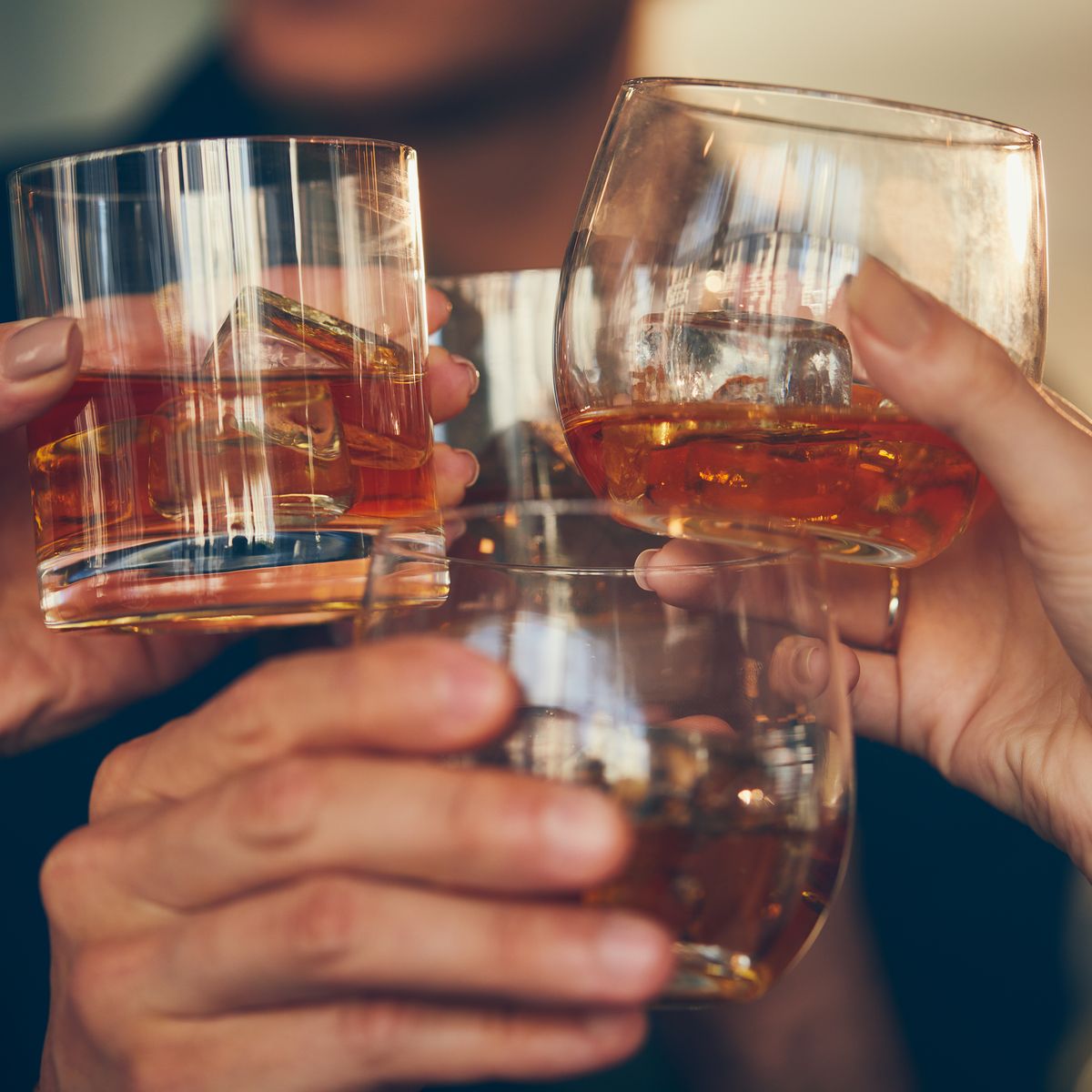 Three people makes a toast with whiskey