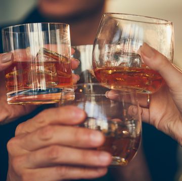 Three people makes a toast with whiskey