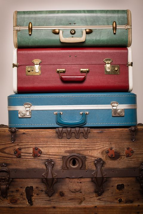 Three Retro Suitcases Stacked on Wood Trunk