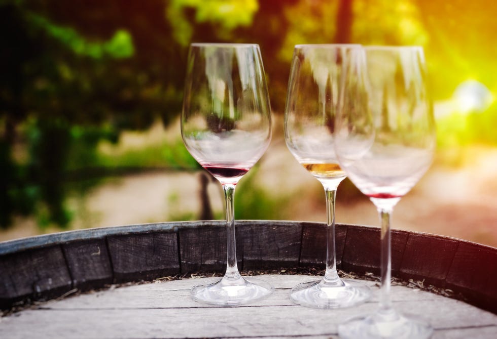 three wine glasses on barrell at vineyard in sonoma, california