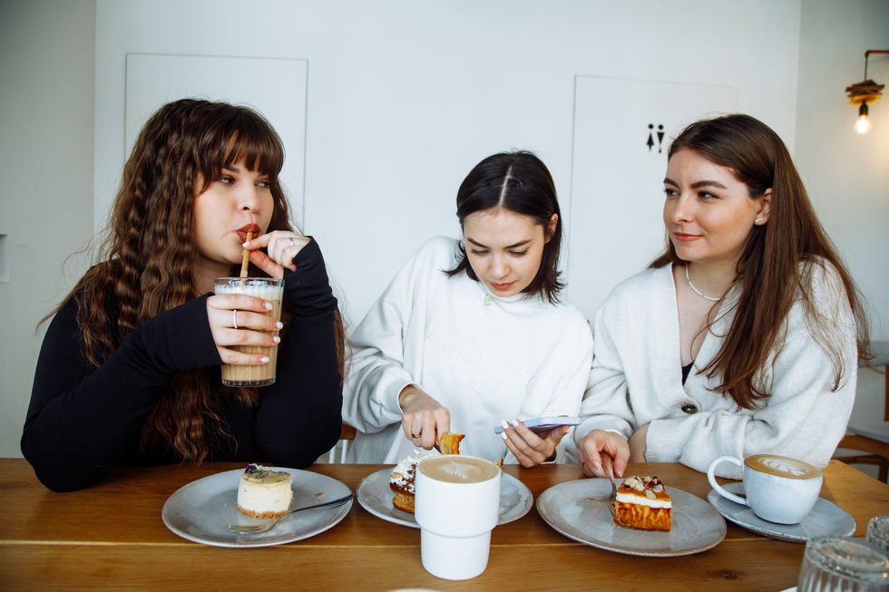 three women eating desserts and drinking coffee enjoying their time together