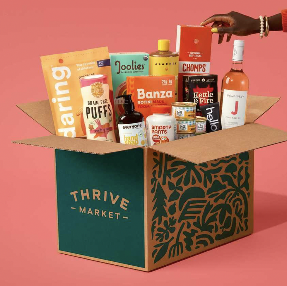thrive market box of groceries on a pink backdrop