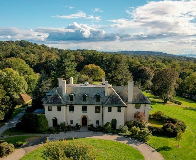 a large white house surrounded by trees