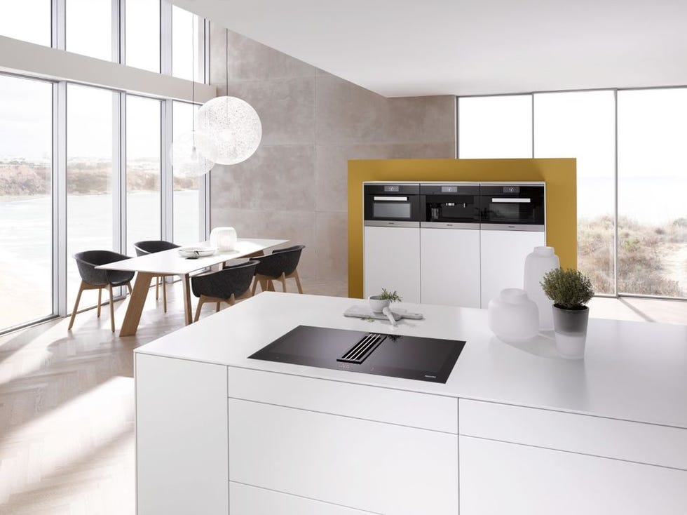 White kitchen island with induction hob featuring integrated extractor
