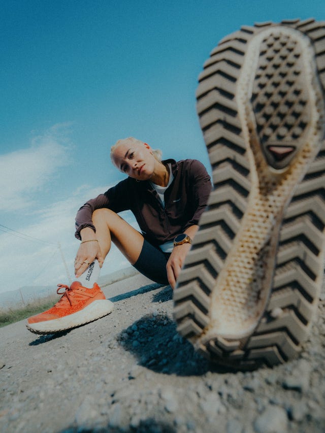 a person relaxing on a gravel road showcasing running shoes and a closeup view of a shoe sole