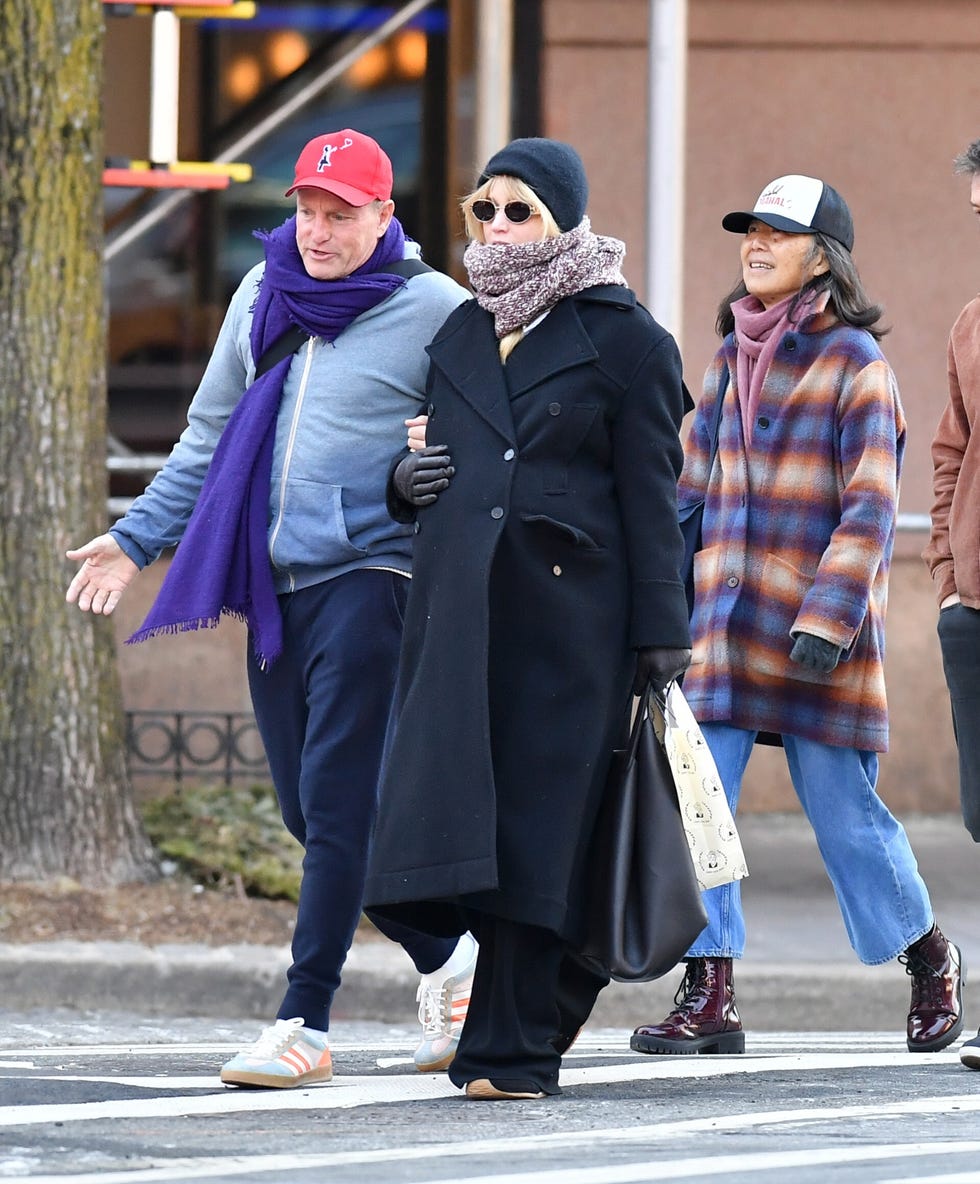 group of individuals walking on a city street during chilly weather