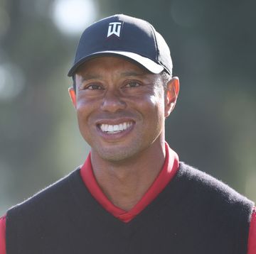 tiger woods smiling at the conclusion of a golf tournament