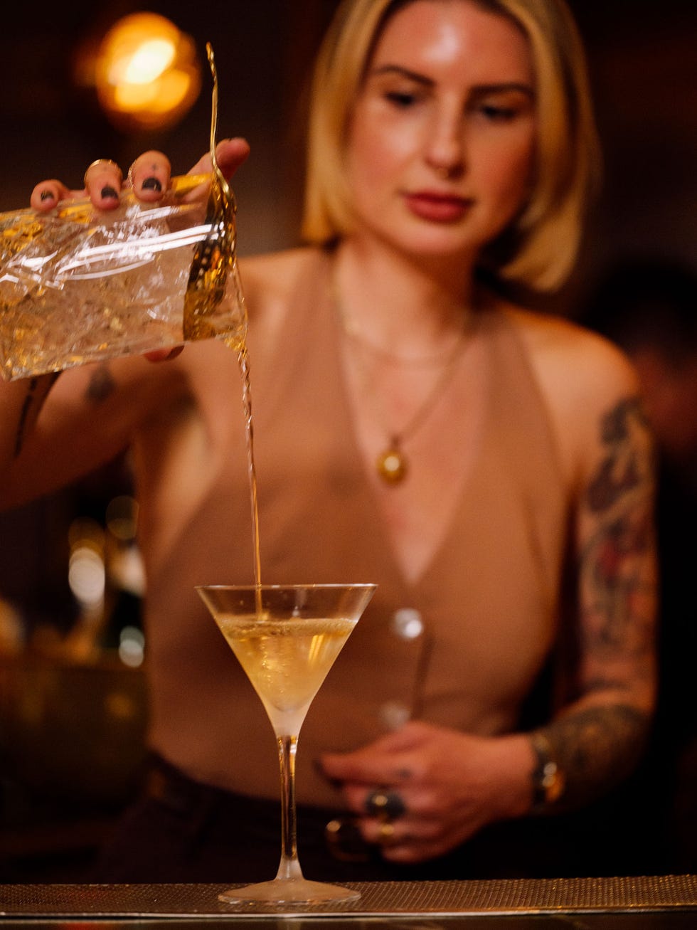 a woman pouring a drink into a glass