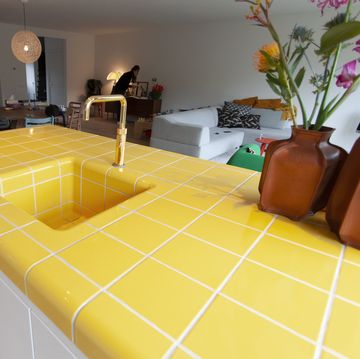 a room with a yellow and white tile floor and a couch