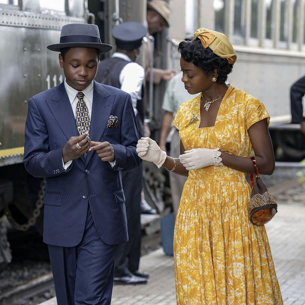 couple dressed in vintage attire engaged in conversation at a train station