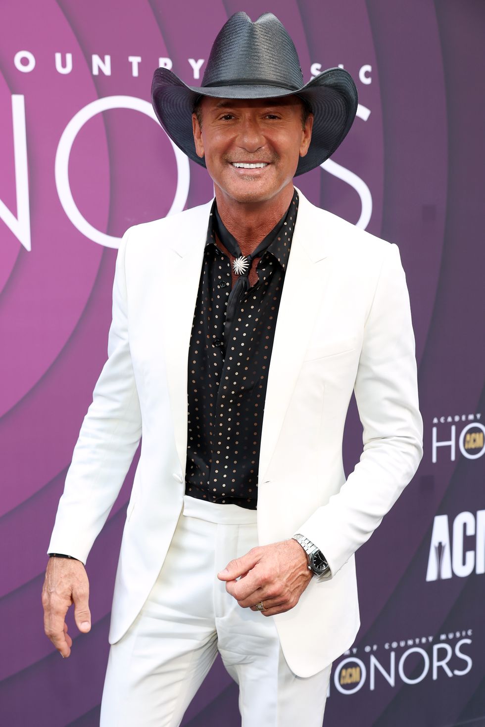 tim mcgraw wearing a white suit and black cowboy hat at an awards show