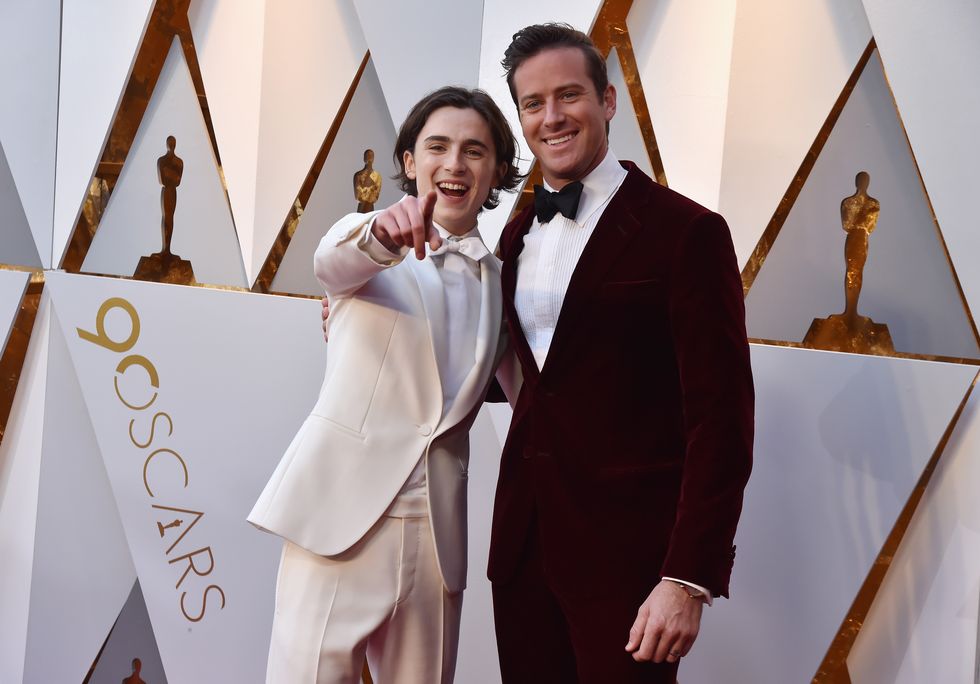 timothee chalamet pointing at a camera as he takes a photo with armie hammer